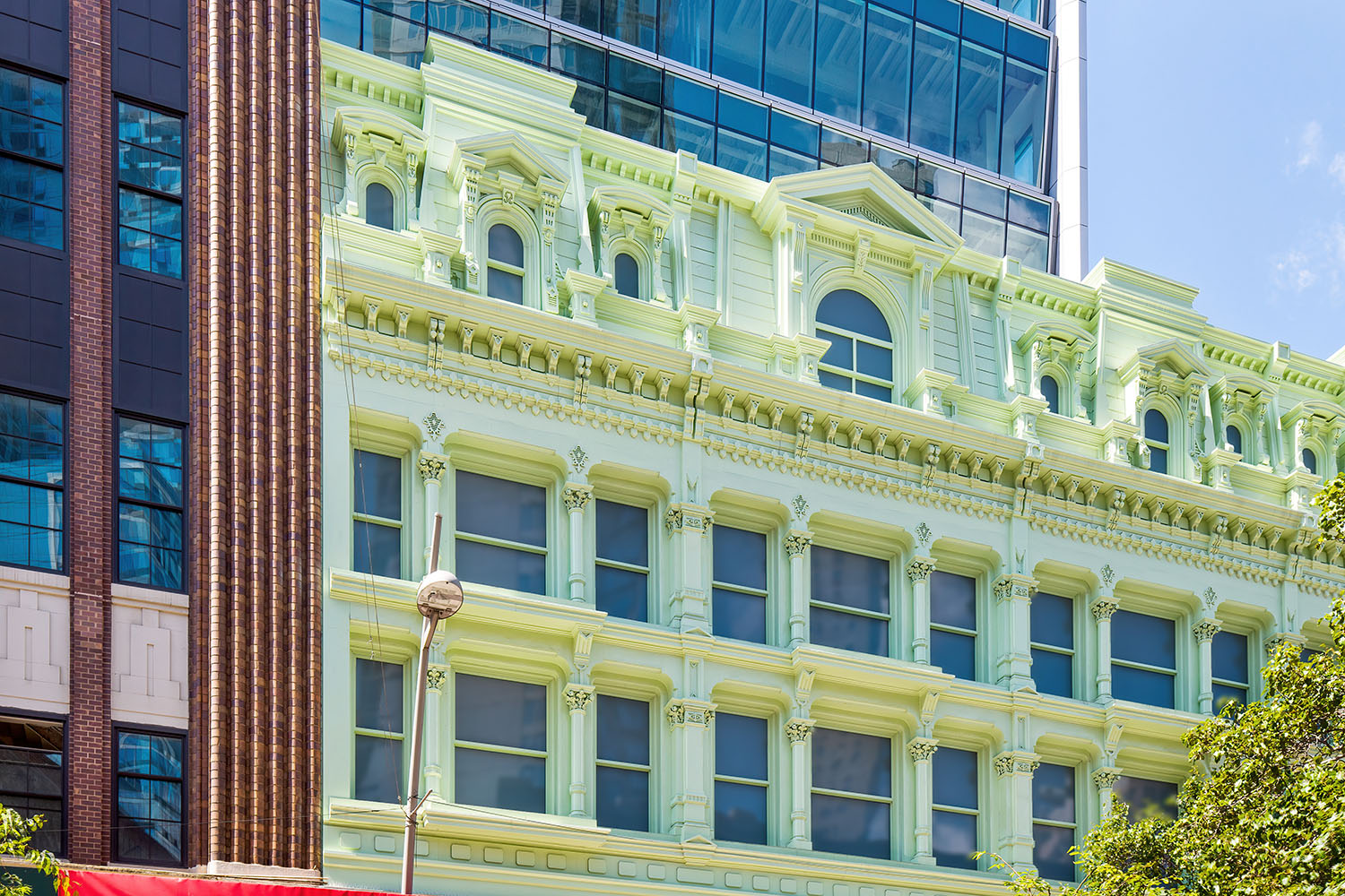 Large historical building with white siding. Three floors are shown in the image.