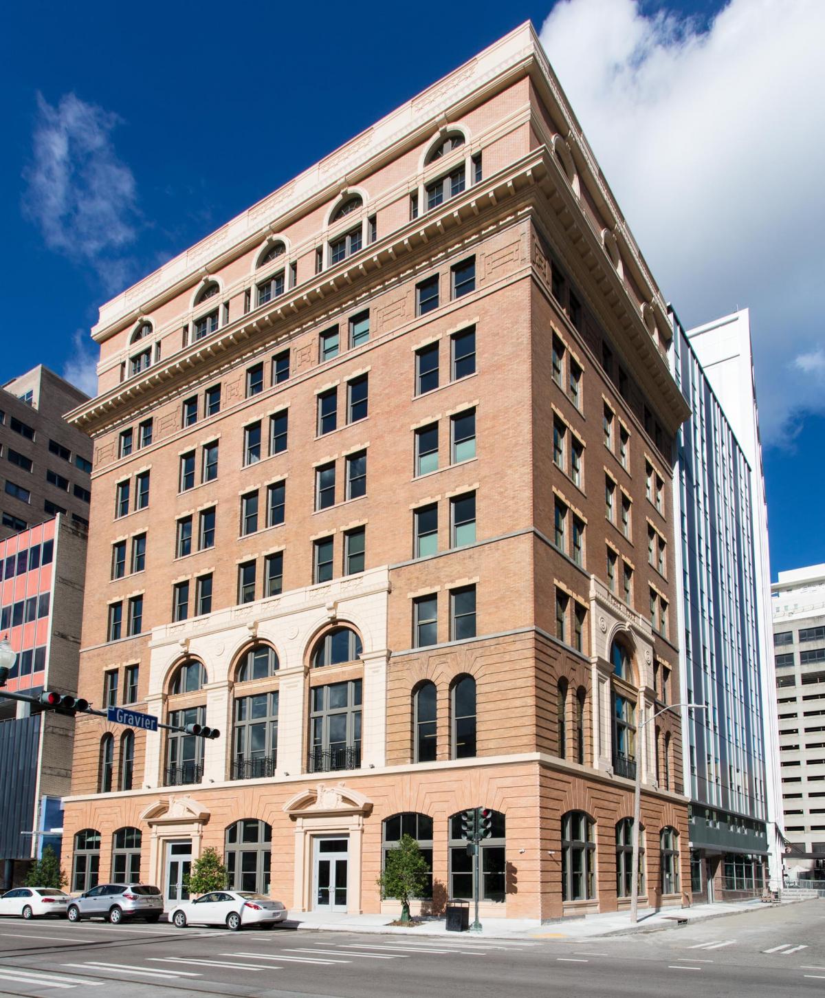 This building has large windows that overlook the city. The walls are white, and there are hardwood floors.