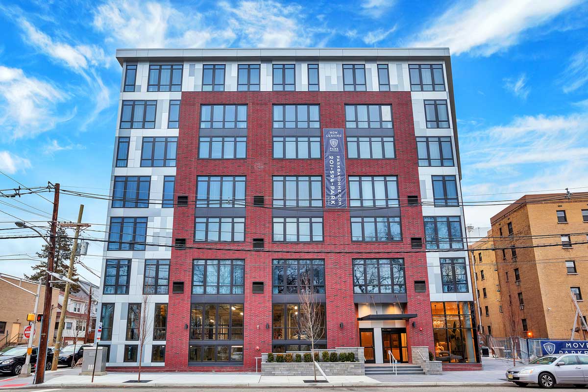 Building entrance with tall windows and sky in background