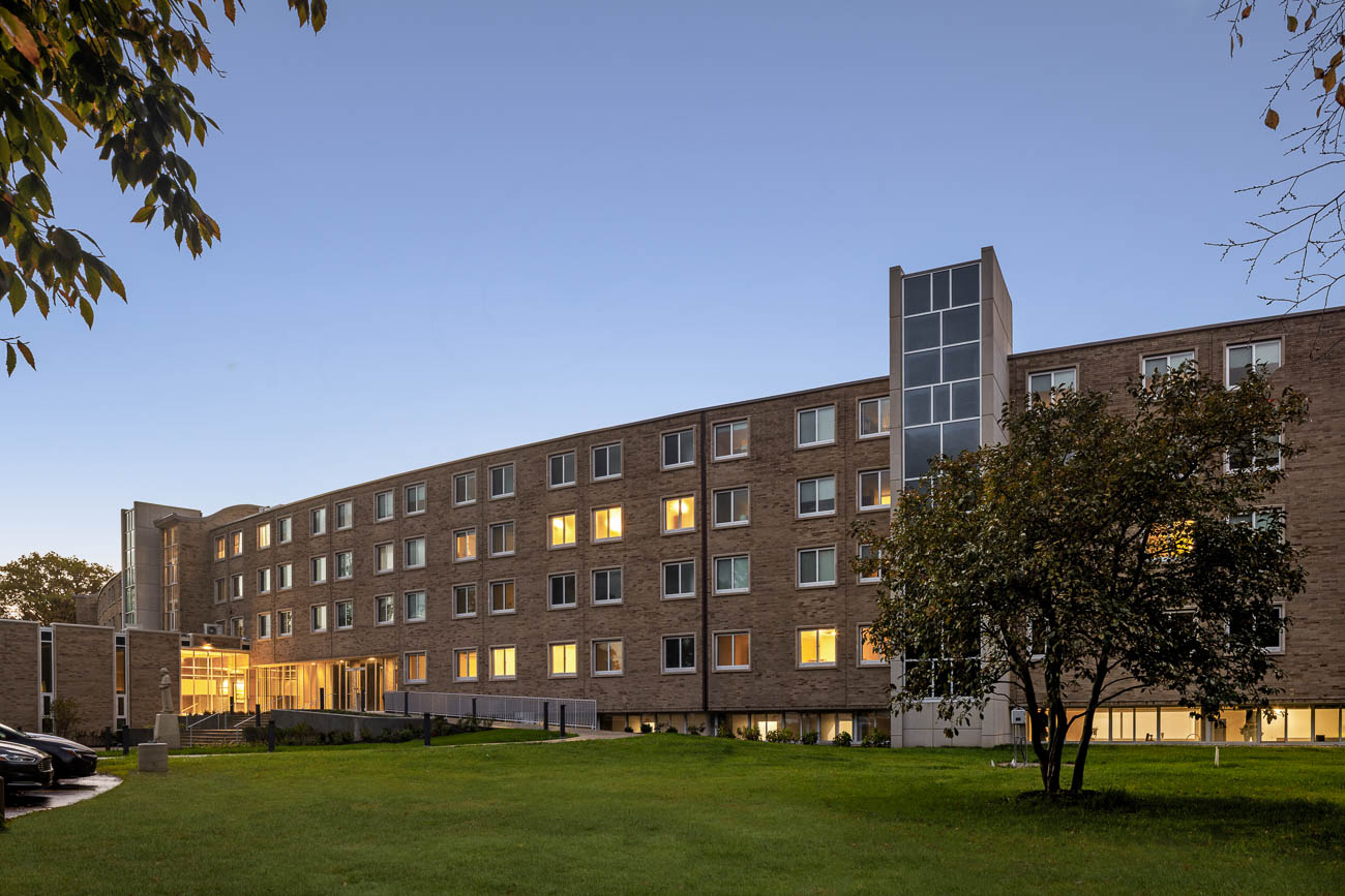 Large historic building surrounded by a lush lawn and trees, representing Moreau Seminary at the University of Notre Dame..