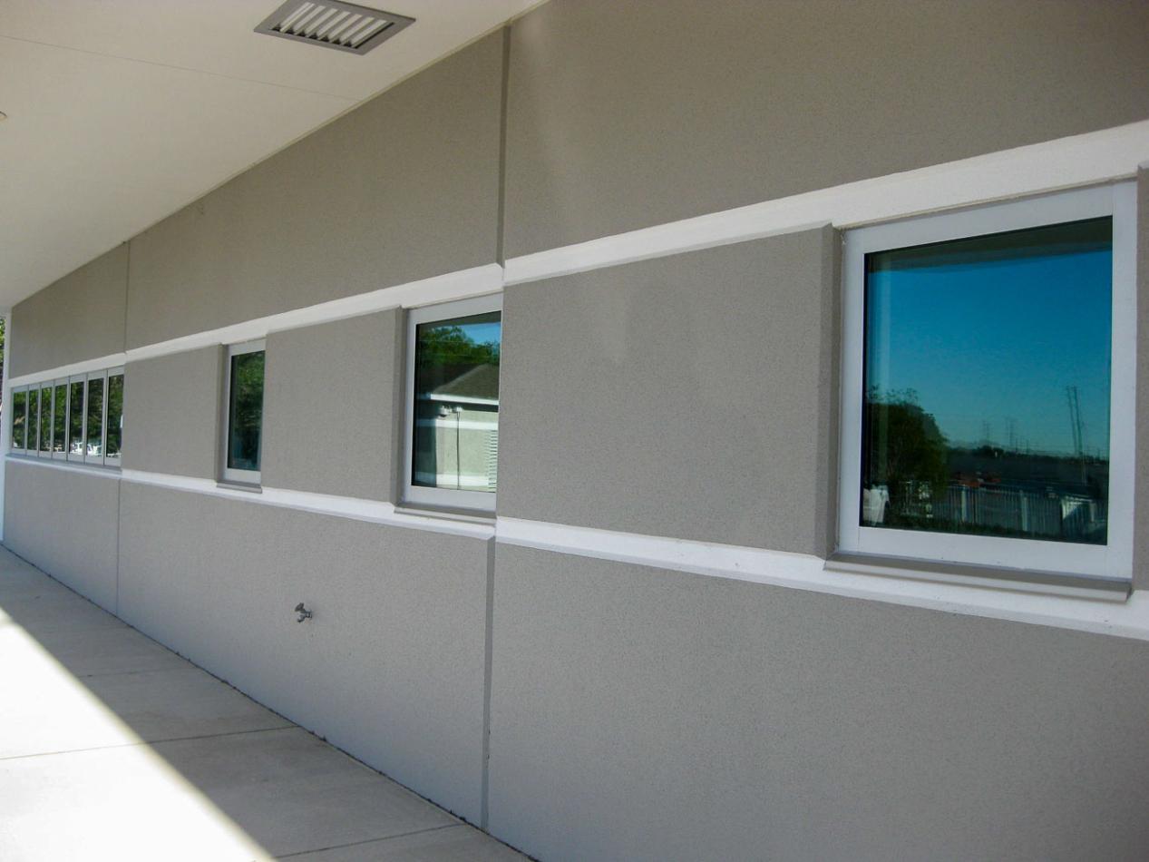 Close-up of a window with glass, featuring a tornado resistant window. The setting includes indoor and outdoor elements, highlighting the fixture attached to the wall of a building.