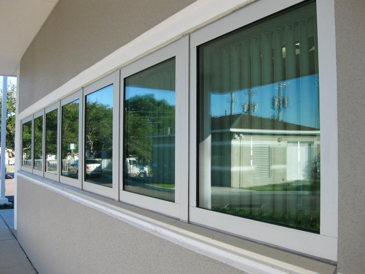 Close-up of a building, featuring a tornado resistant window. The setting includes indoor and outdoor elements, highlighting the fixture attached to the wall of a building.