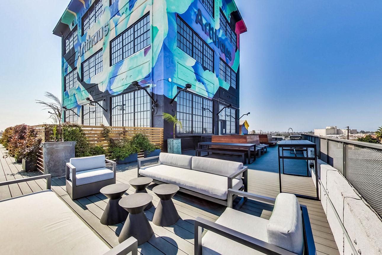 Artthaus Studios_Exterior colorful brick building with large black anodized windows and patio furniture.