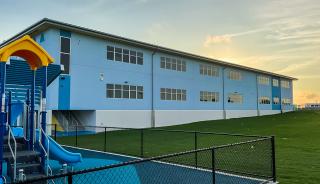 Exterior blue building with gras and slide in front
